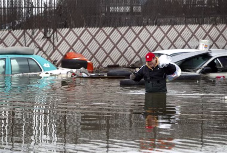 Wading through waist-deep water, Scott Kibrick, of Hopewell Junction, N.Y., retrieves items from the flooded office of the cab company he owns, Friday, March 11, 2011, in Elmsford, N.Y.  Heavy rains overnight led the Saw Mill River and others to overflow their banks, causing major flooding across Westchester County. (AP Photo/Jason DeCrow)